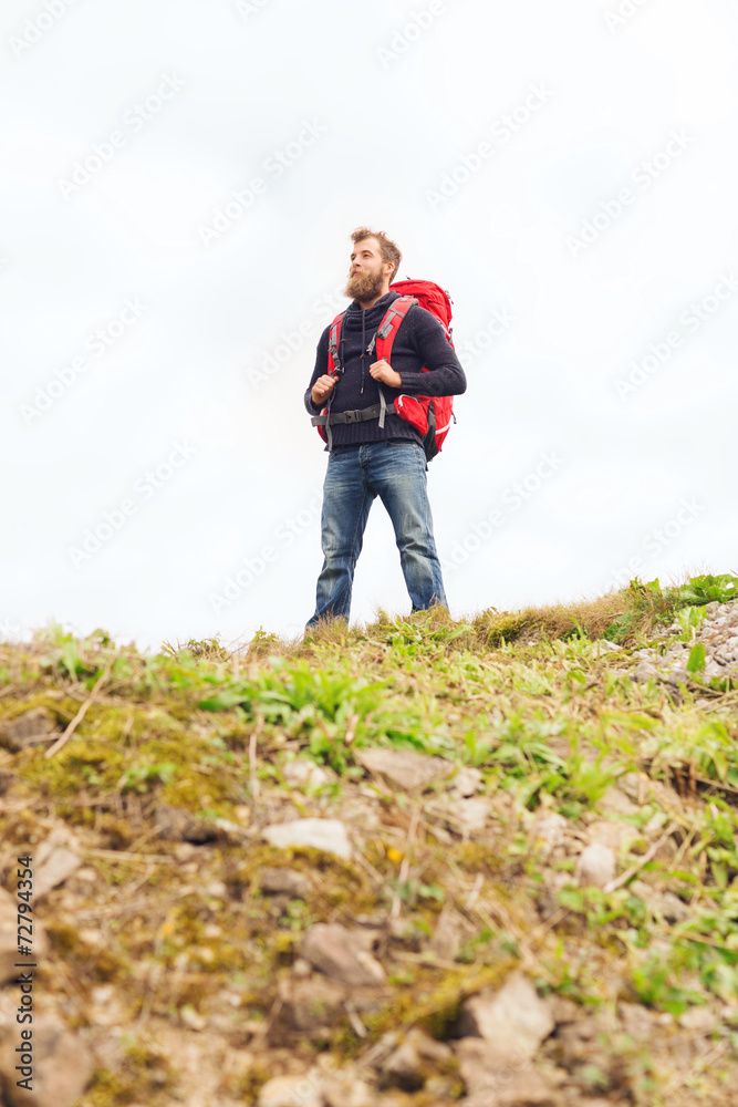 tourist with beard and backpack raising hands