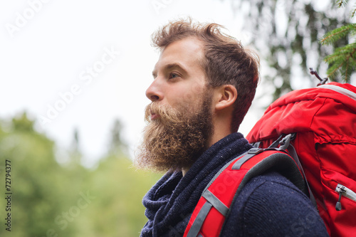 smiling man with beard and backpack hiking