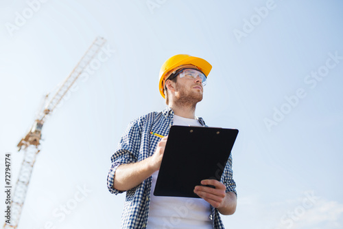 Obraz na plátně builder in hardhat with clipboard outdoors