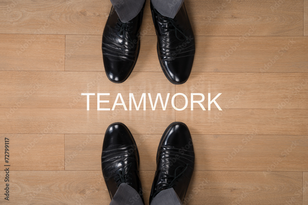 Businessmen Standing With Teamwork Written On Floor Businessmen Standing With Teamwork Written On Floor