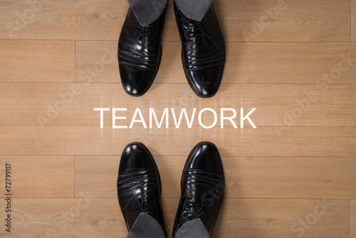 Businessmen Standing With Teamwork Written On Floor