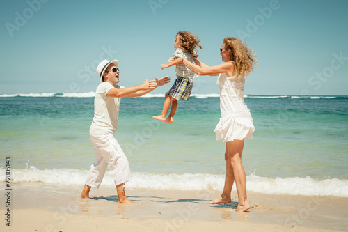 Happy family playing on the beach at the day time