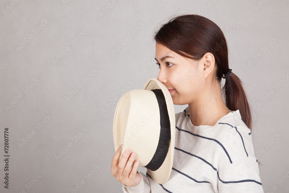 Beautiful Asian girl hold a hat close her mouth Beautiful Asian girl hold a hat close her mouth
