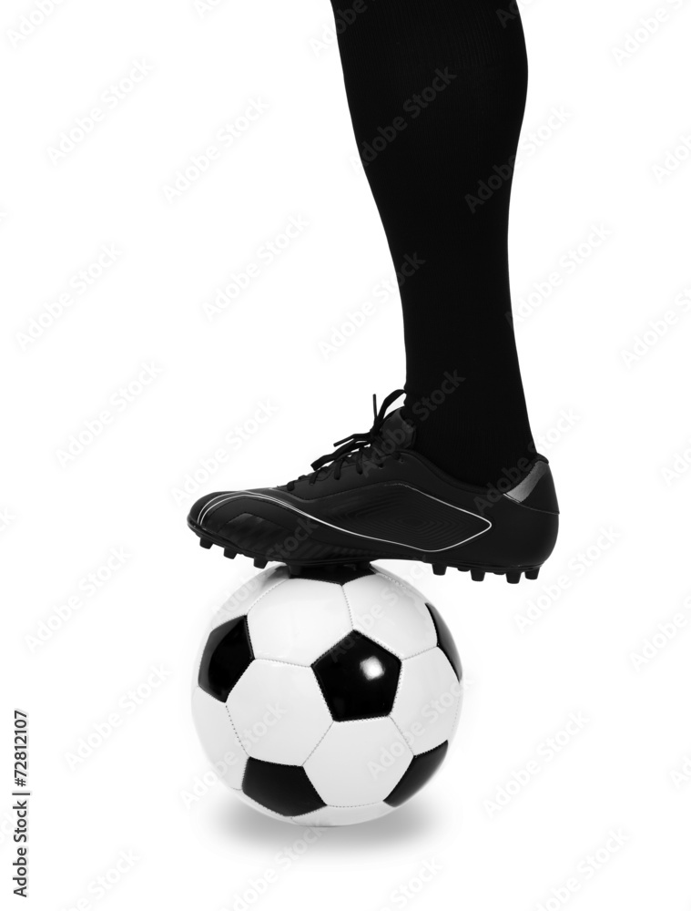Leg of soccer player with ball on white