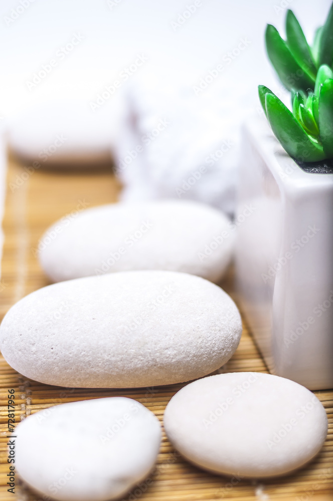 spa, heath and beauty concept - massage stones,towel with flower