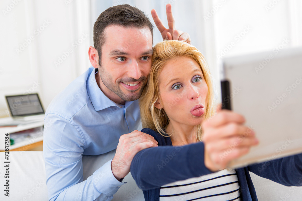 Fototapeta premium Young attractive couple having fun doing selfie