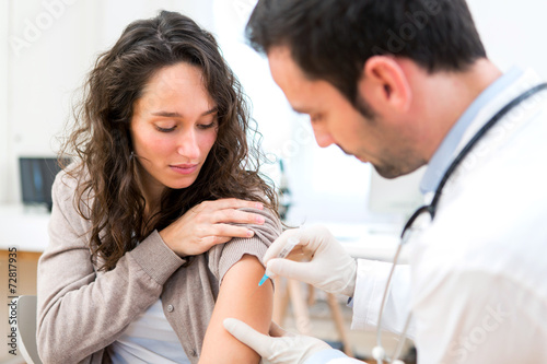 Young attractive woman being vaccinated photo