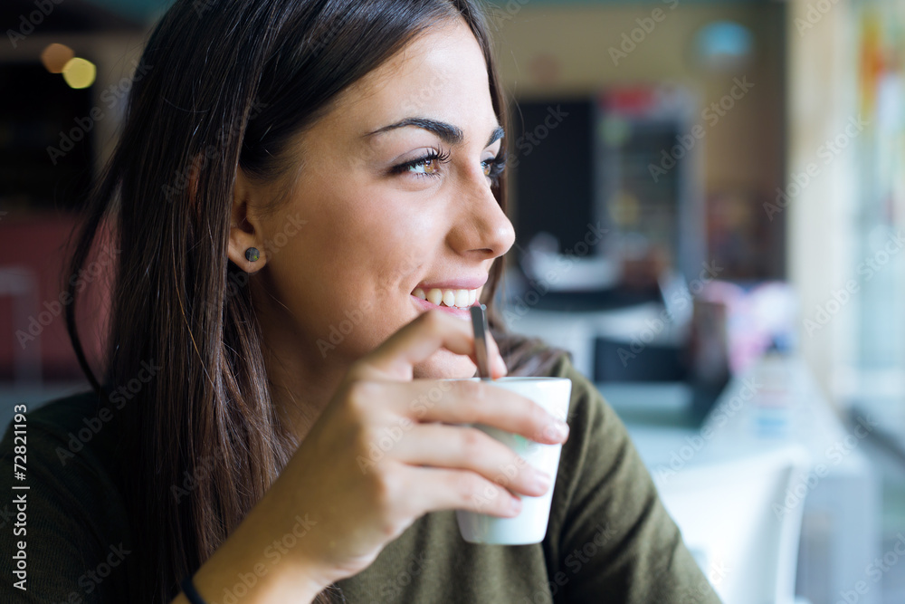 Beautiful girl drinking coffee sitting indoor in urban cafe. Beautiful girl drinking coffee sitting indoor in urban cafe.