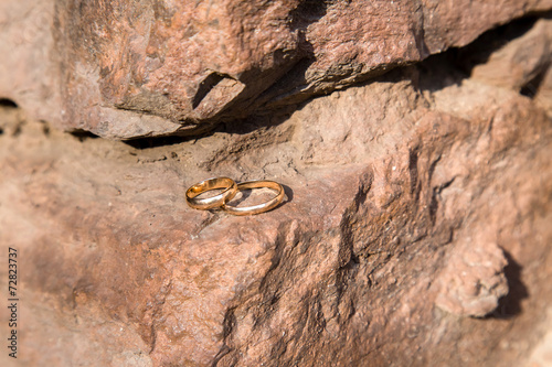 two wedding rings on a stone wall photo