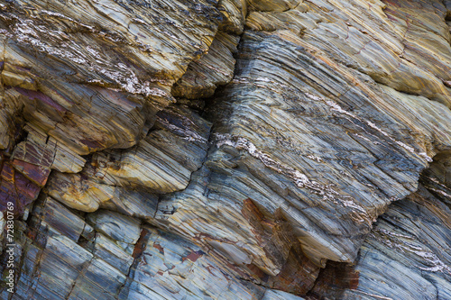 Foto Colored granite and schist rock face