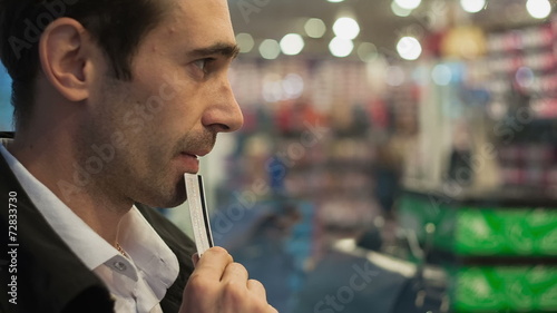 A young man with a credit card hesitate in buying at the