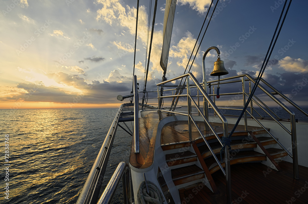 Naklejka premium Yacht Sailing against sunset. Sailboat. Sailing