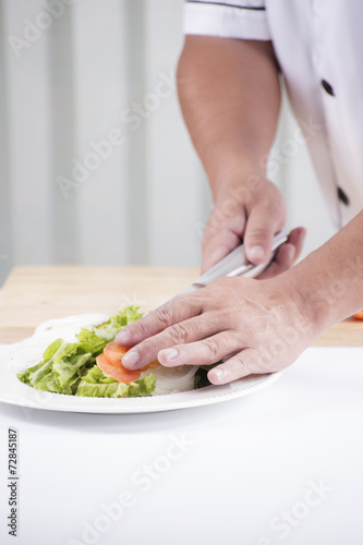 Fototapeta Naklejka Na Ścianę i Meble -  Chef's hands cutting Tomato