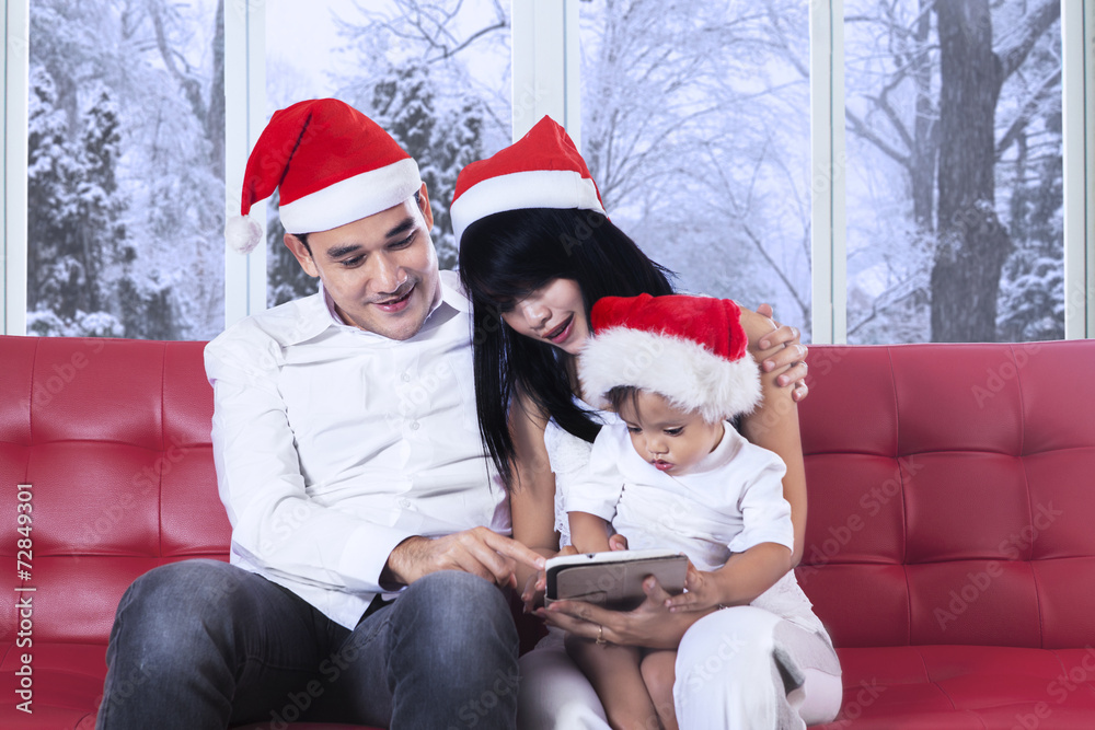 Child with parents using tablet on sofa Child with parents using tablet on sofa