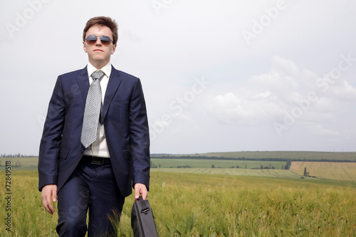 Businessman goes along the field