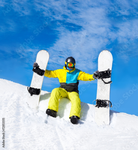 snowboarder hold two snowboards sitting on snow