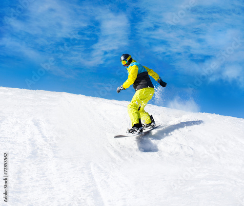 Snowboarder sliding down the hill, snow mountains