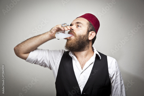 Man in traditional turkish hat dress kabadayi with alcohol raki photo