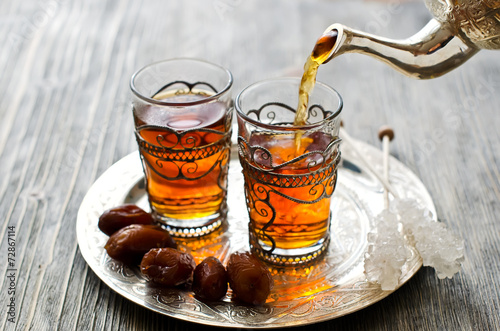 Traditional arabic tea with dates and sugar on a plate photo