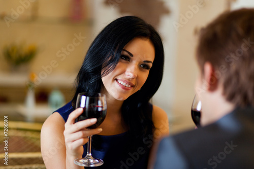 Young happy couple romantic date drink glass of red wine at