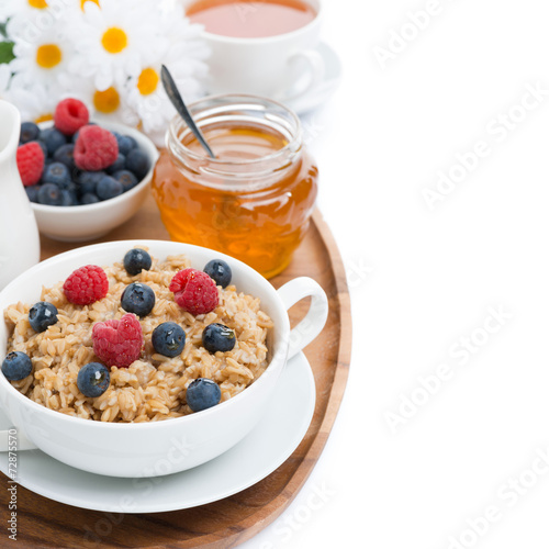 oat porridge with berries and honey, black tea, isolated