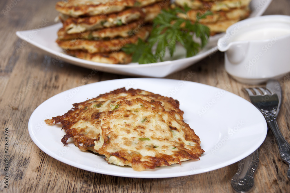 Vegetable fritters of zucchini with parsley and dill closeup  .