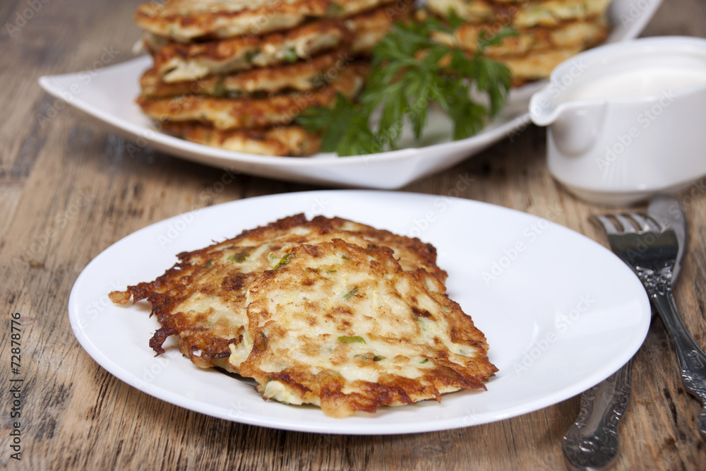 Vegetable fritters of zucchini with parsley and dill closeup . Vegetable fritters of zucchini with parsley and dill closeup .