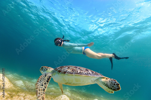 Obraz na płótnie Young girl snorkeling with sea turtle