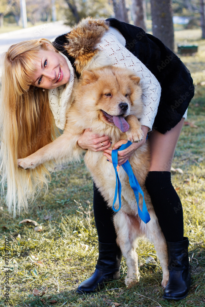 Fototapeta premium Attractive girl with her dog wearing warm clothes