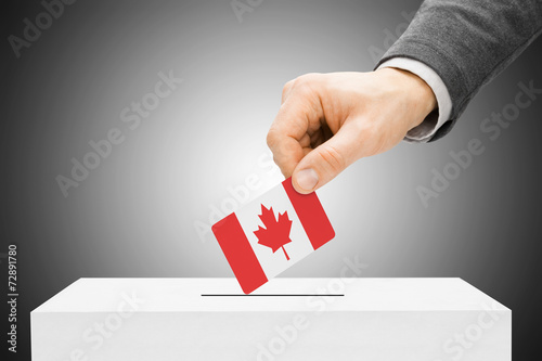 Voting concept - Male inserting flag into ballot box - Canada photo