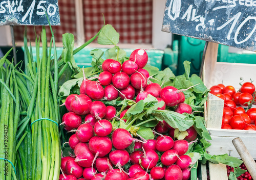 Garden radish and spring onions on a market stall photo