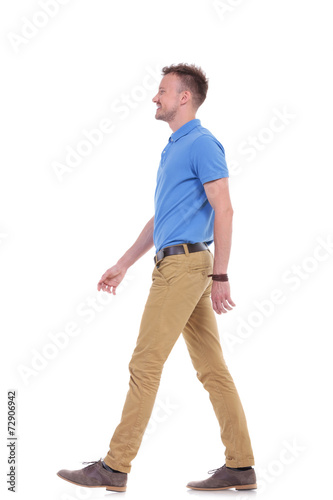 side of casual young man walking