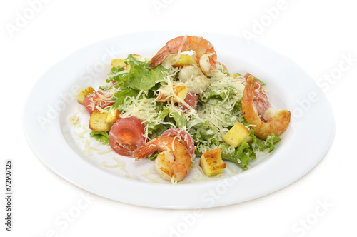 Salad with shrimps and vegetables on white plate isolated