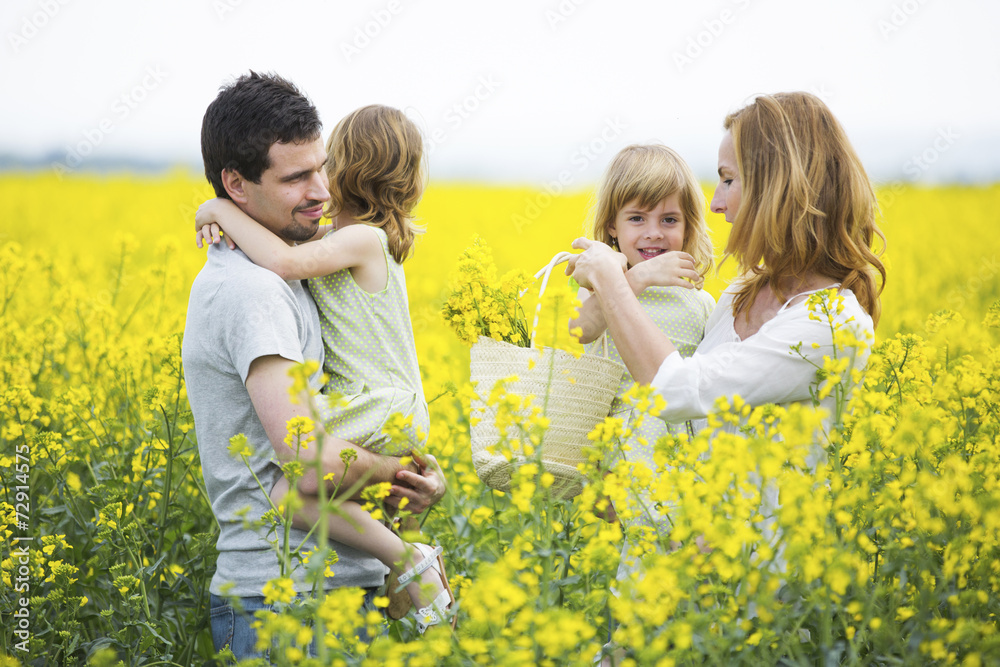 Familie mit Zwillingsmädchen steht in Rapsfeld Familie mit Zwillingsmädchen steht in Rapsfeld