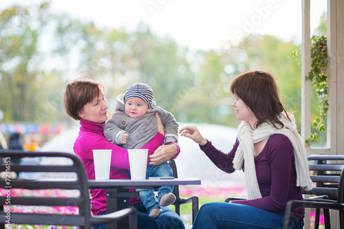 Grandmother, mother and little son in cafe