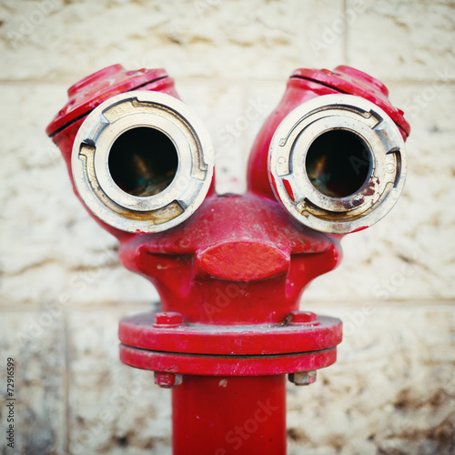 Red old fire hydrant on a street. Smiley face.