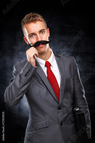 Young businessman with fake mustaches pretends to be older  © cherryandbees