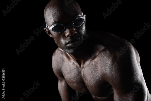African athlete with swimming goggles looking away