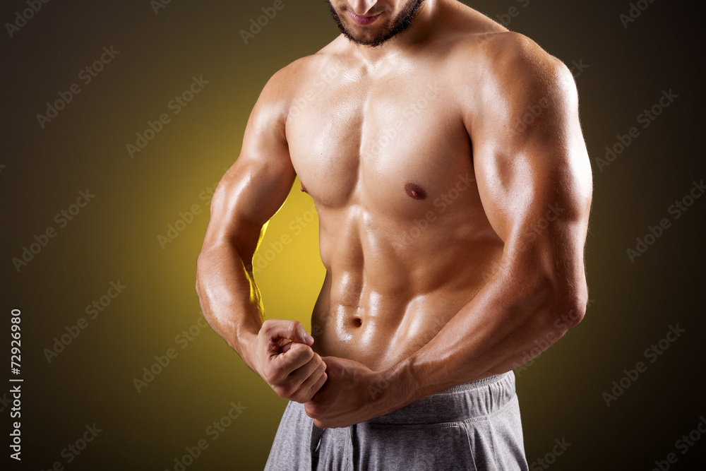 Fototapeta premium Fit man with beautiful torso posing on dark background