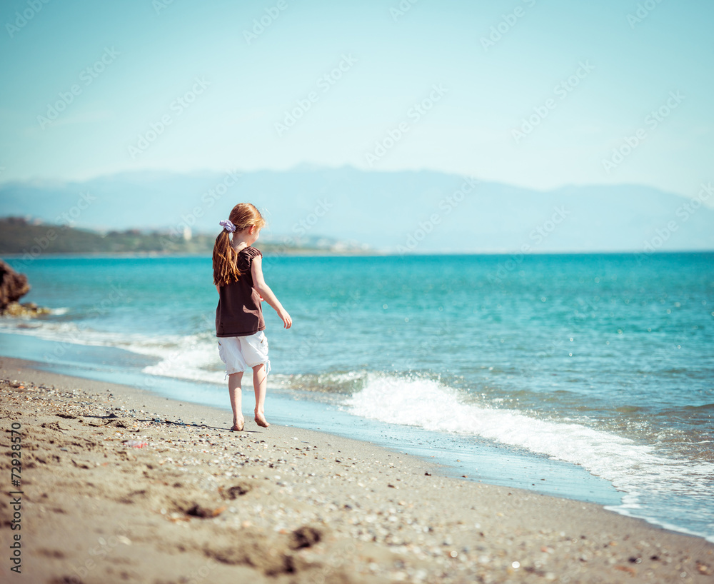 little girl walks on the  beach