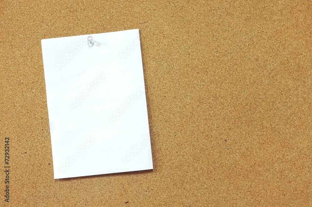 Blank memo paper pinned on cork noticeboard Blank memo paper pinned on cork noticeboard