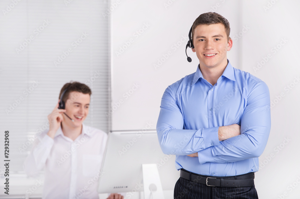 two young call center men talking by phone. two young call center men talking by phone.
