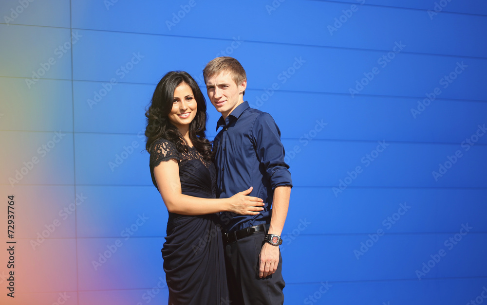 Cheerful couple with a blue wall on background