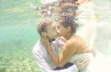 Bride and groom in the ocean water diving