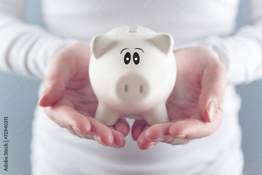 Woman holding piggy coin bank in hands Woman holding piggy coin bank in hands