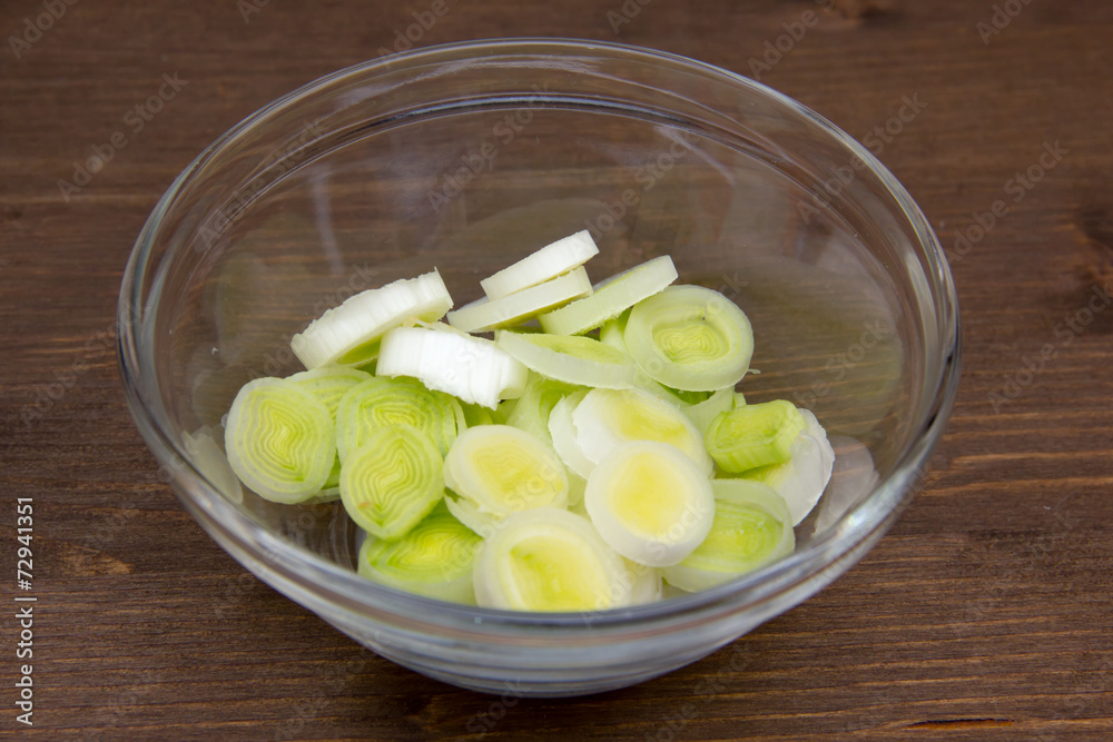 Bowl with sliced leek on wooden table Bowl with sliced leek on wooden table