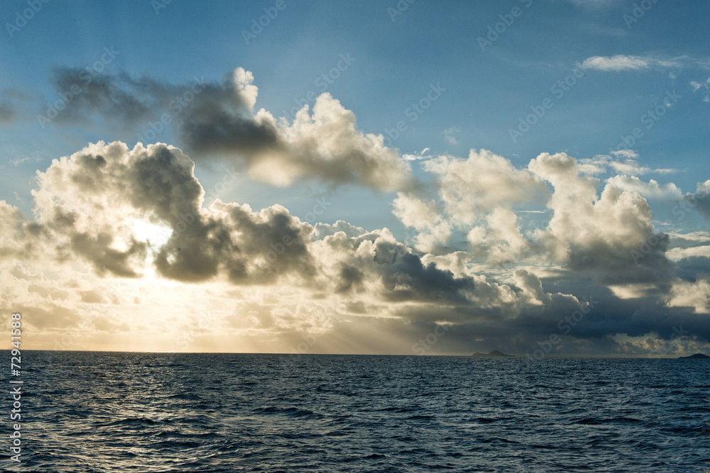 Backlit clouds over a tranquil ocean