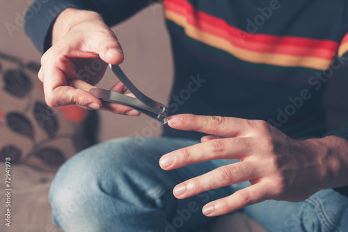 Man clipping his finger nails photo