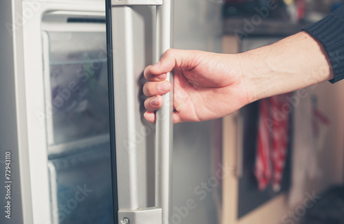 Hand opening freezer door photo