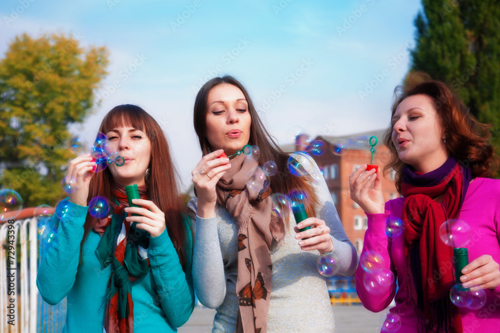 Three young beautiful women blow bubbles Three young beautiful women blow bubbles
